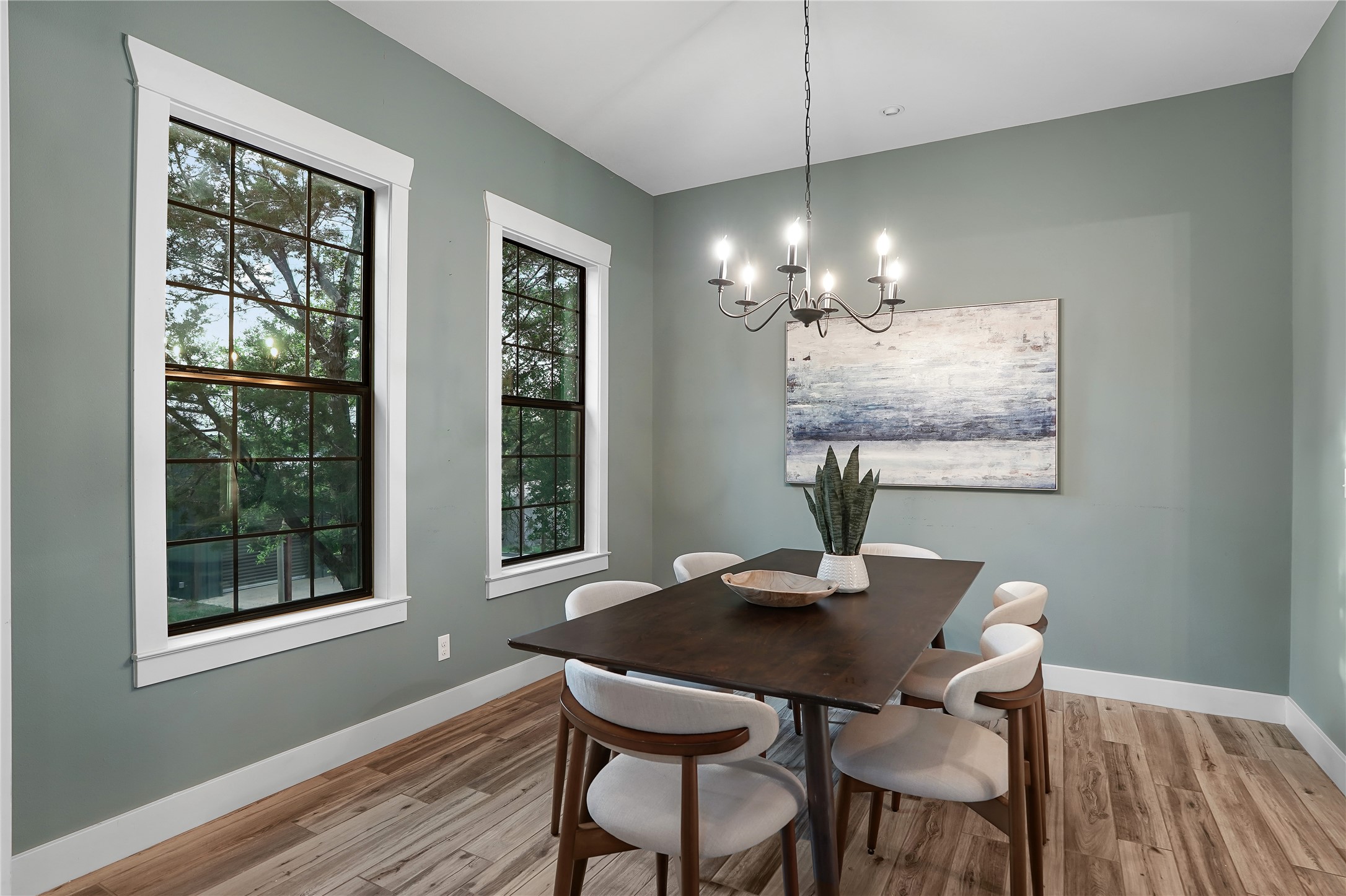 786 Beauchamp Road Dripping Springs, TX 78620 - Photo 12 of 40 Dining area featuring light-toned wood floors, two large windows with dark gridded panes, and a chandelier with exposed bulbs