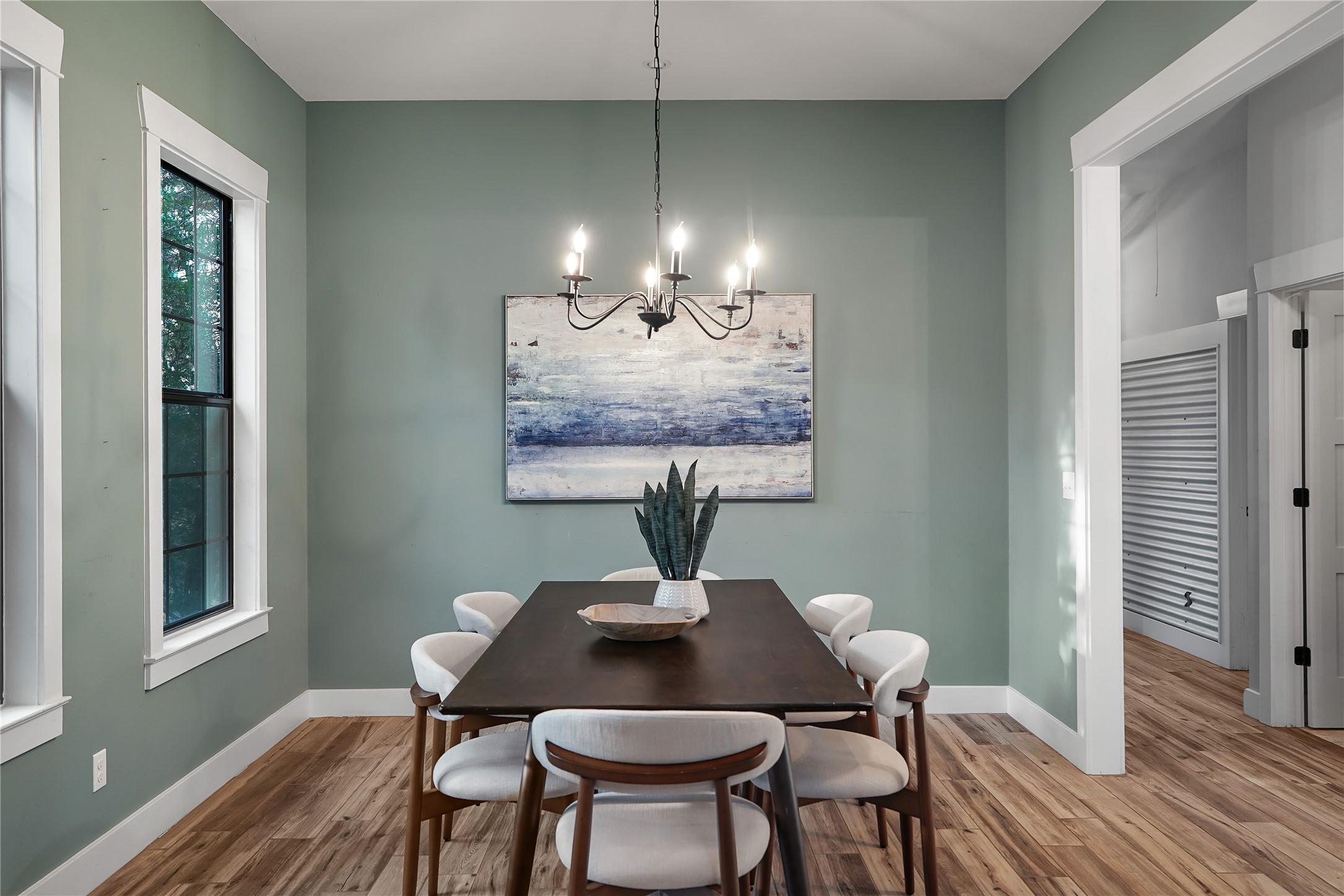 786 Beauchamp Road Dripping Springs, TX 78620 - Photo 13 of 40 This dining area features hardwood floors, a modern chandelier, and a window with white trim