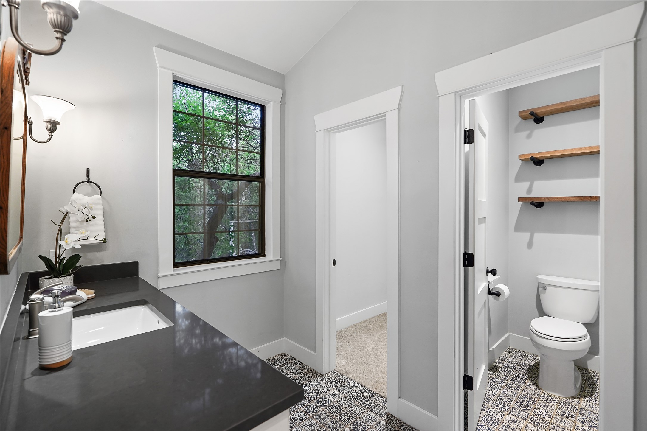 786 Beauchamp Road Dripping Springs, TX 78620 - Photo 17 of 40 This property features a stylish bathroom with a dark countertop and a window providing natural light