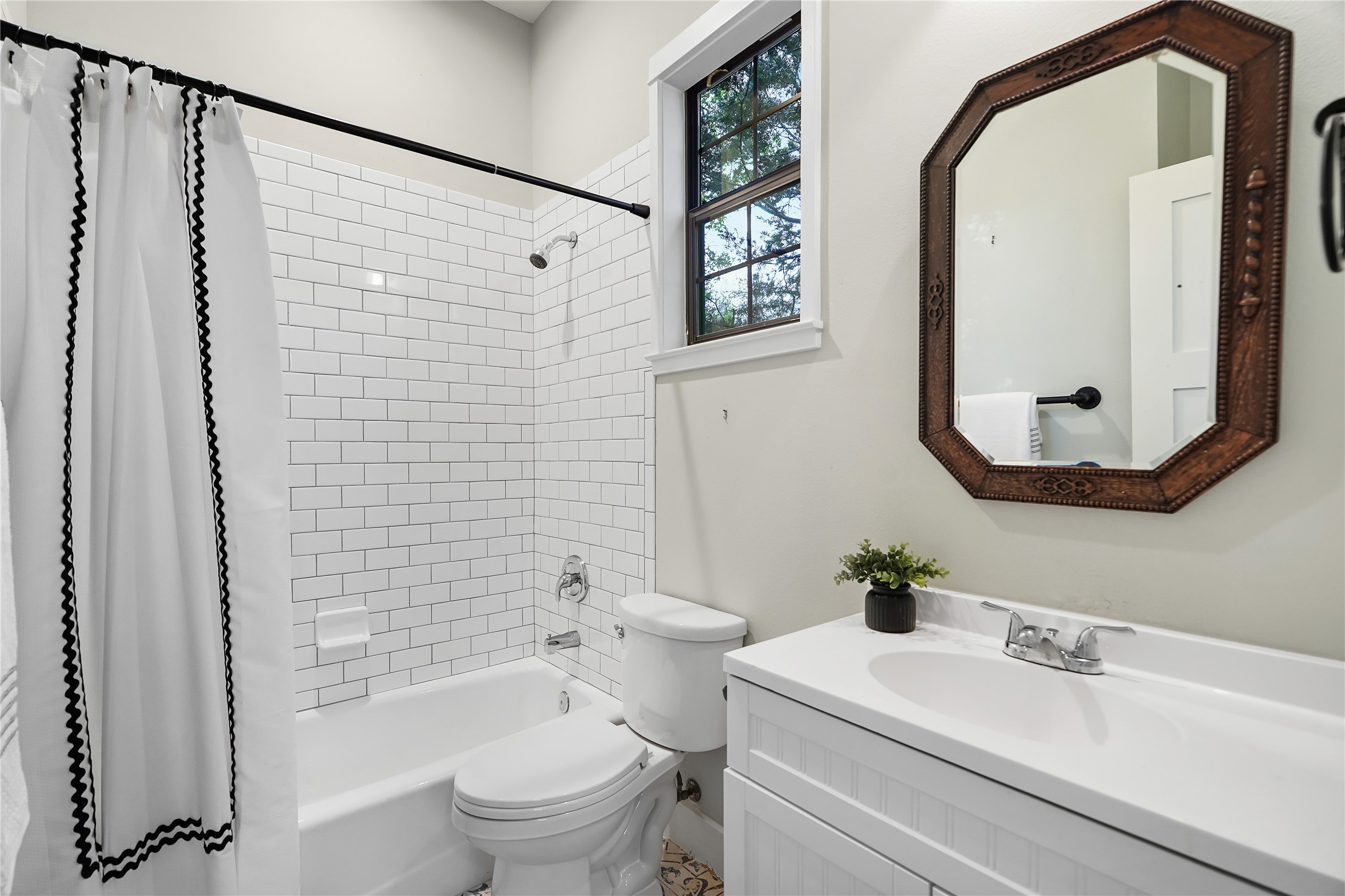 786 Beauchamp Road Dripping Springs, TX 78620 - Photo 22 of 40 The bathroom features a bathtub with subway tile surround, a window providing natural light, and a vanity with a sink and mirror