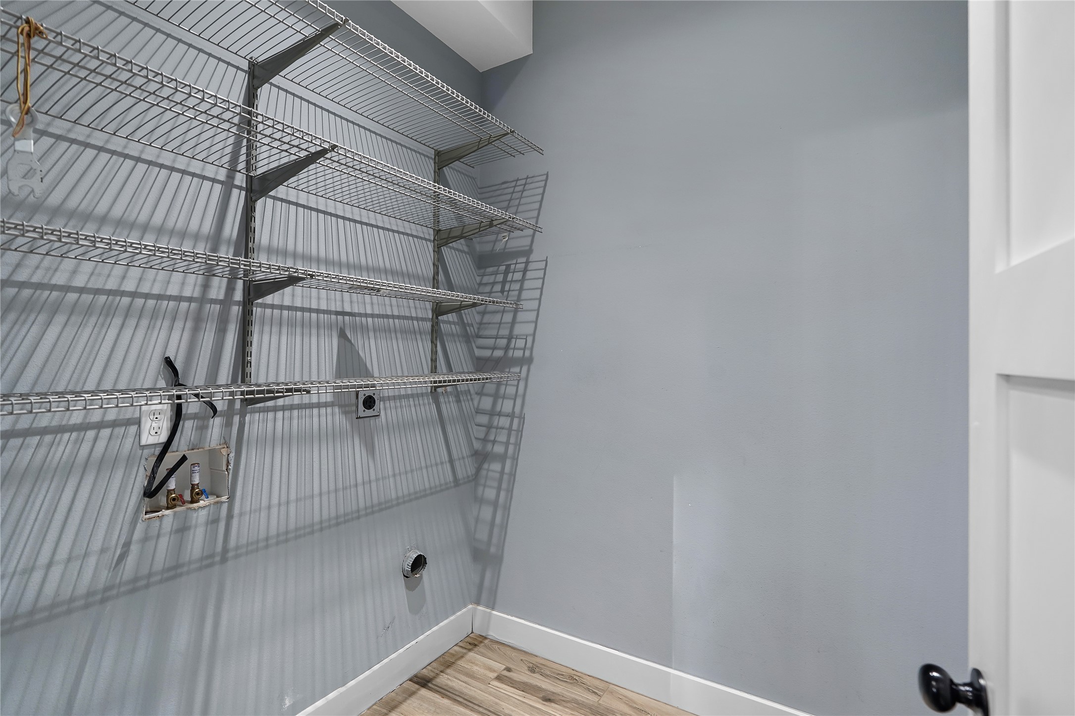 786 Beauchamp Road Dripping Springs, TX 78620 - Photo 24 of 40 Laundry area featuring light wood flooring, wire shelving, and appliance hookups