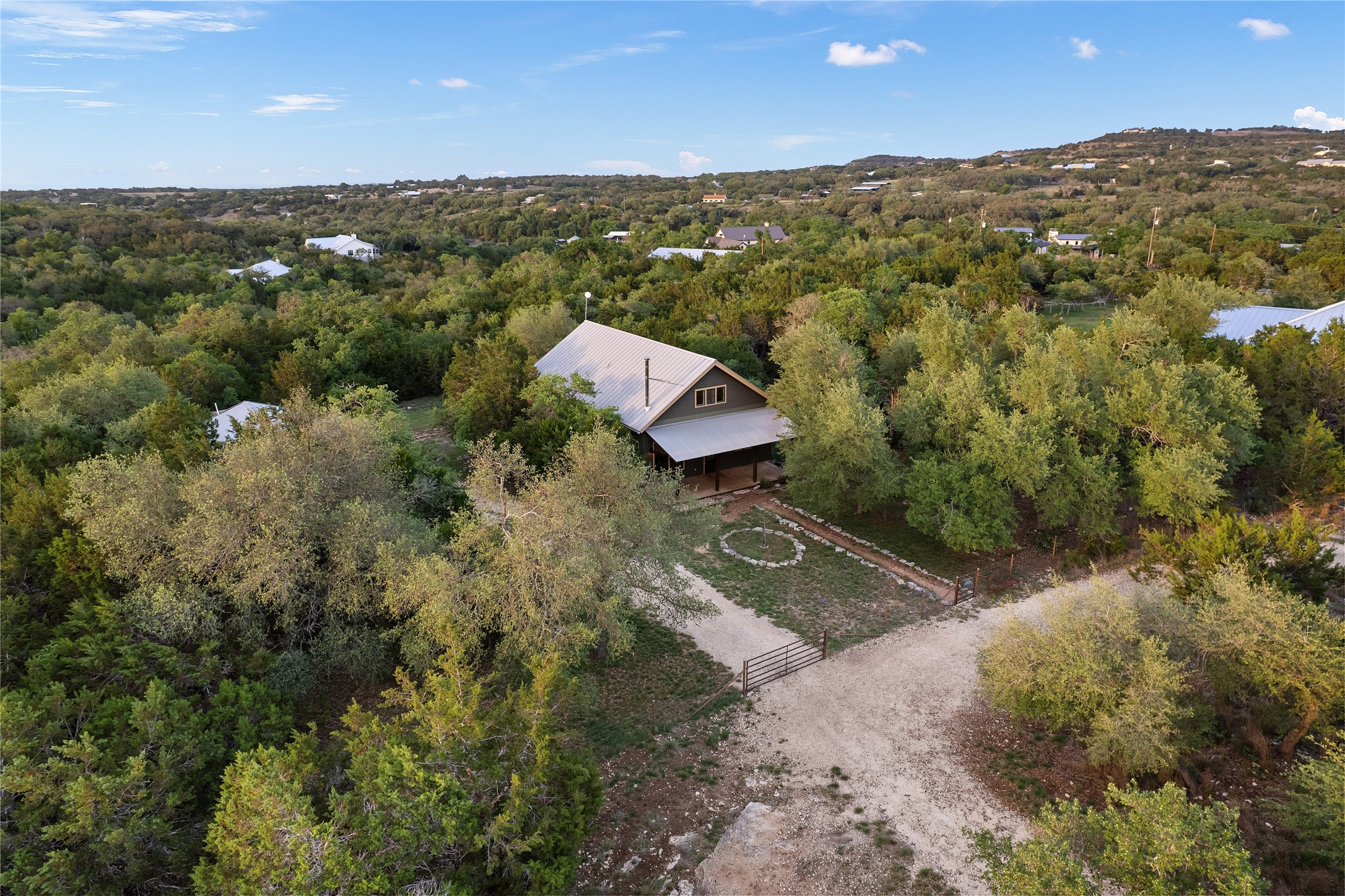 786 Beauchamp Road Dripping Springs, TX 78620 - Photo 40 of 40 The property is nestled amidst extensive greenery, featuring a gravel driveway leading to the residence