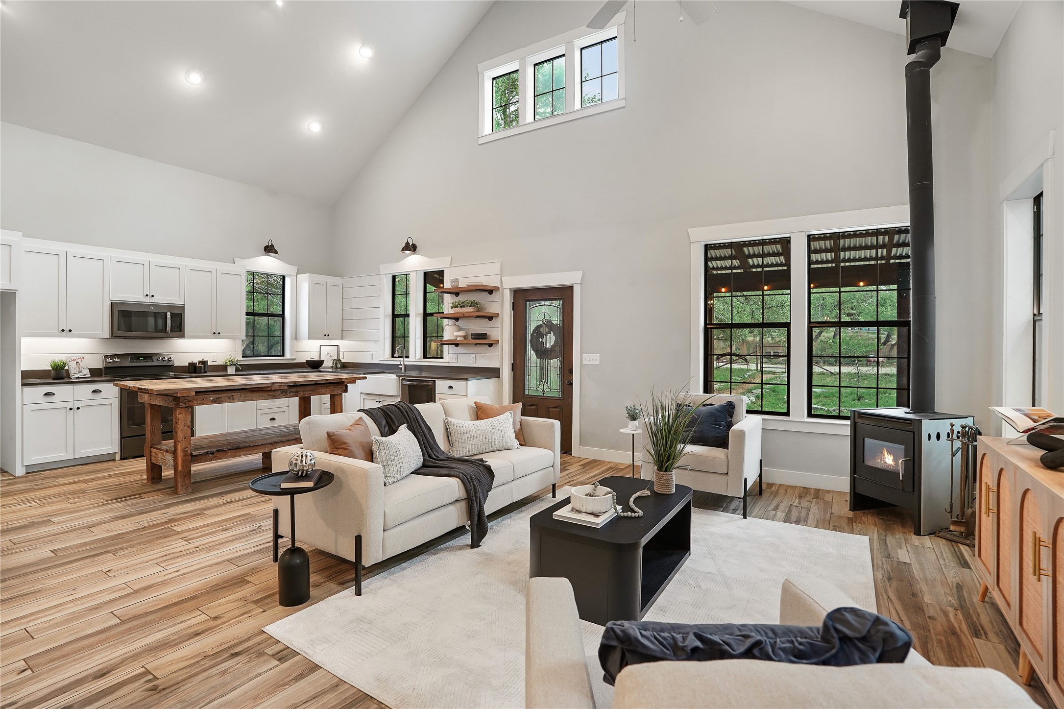 786 Beauchamp Road Dripping Springs, TX 78620 - Photo 10 of 40 Open-concept living area featuring high vaulted ceilings, light wood flooring, and large windows