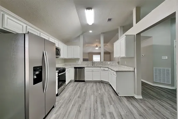 a kitchen with white cabinets and stainless steel appliances