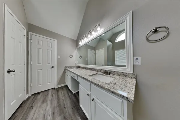 a spacious bathroom with a granite countertop sink and a mirror