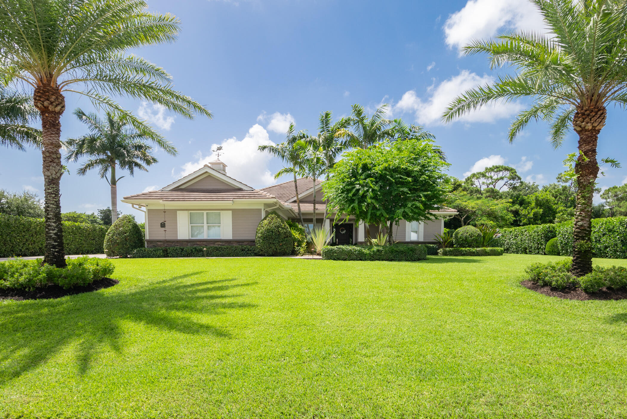 3420 Southeast Golf Trail Stuart, FL 34997 - Photo 1 of 63 a front view of a house with a yard and potted plants