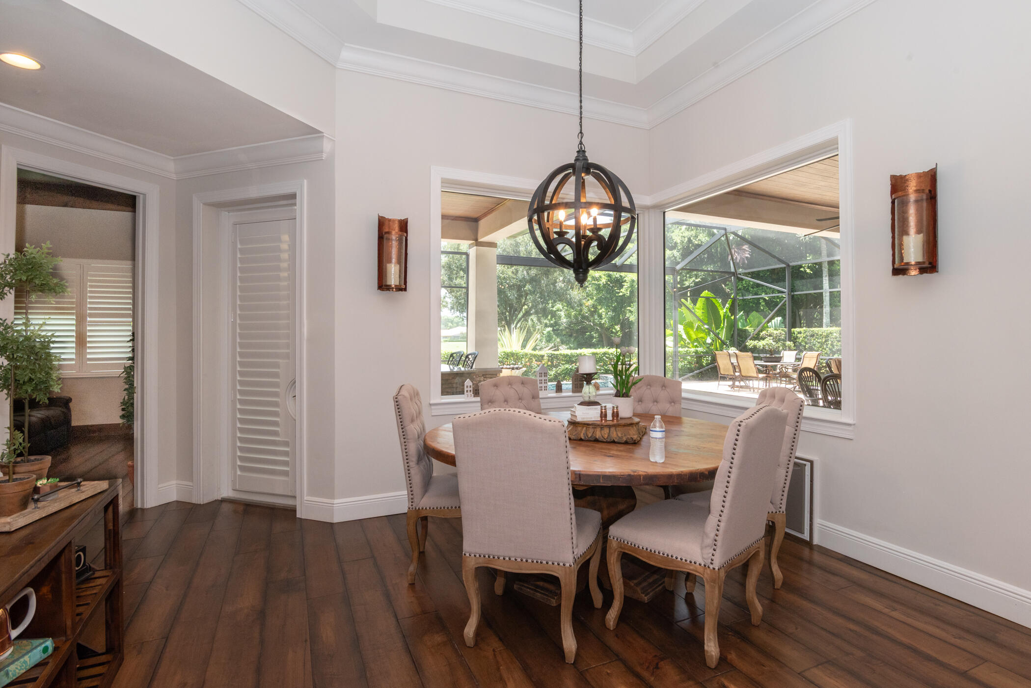 3420 Southeast Golf Trail Stuart, FL 34997 - Photo 14 of 63 a dining room with wooden floor a chandelier a glass table and chairs