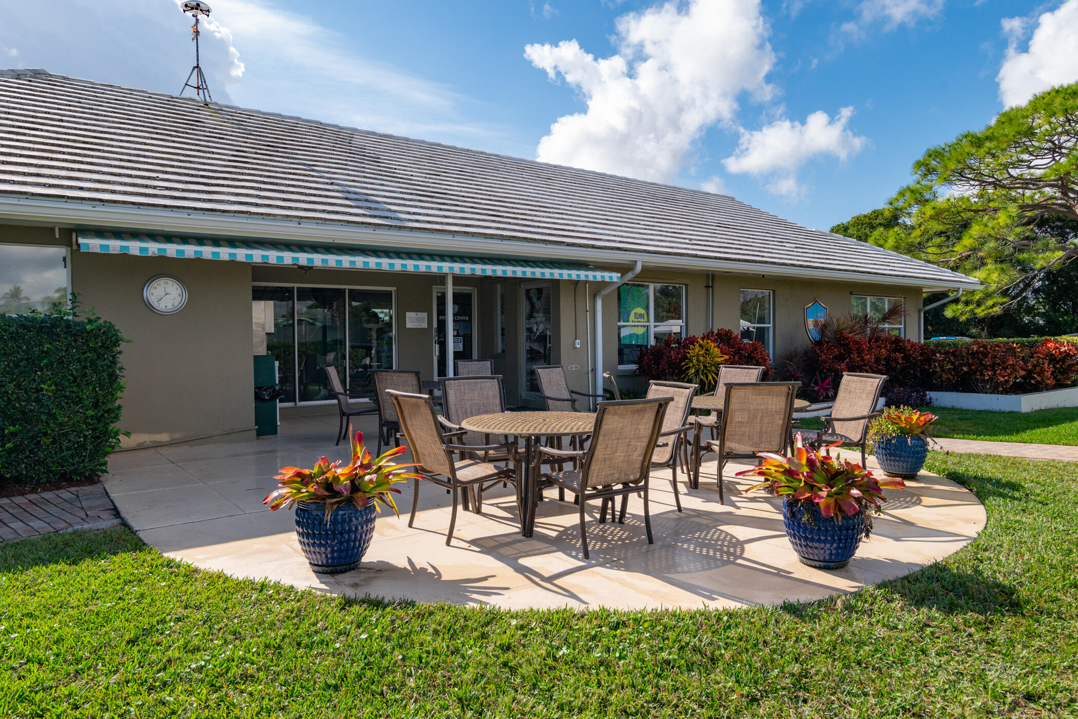 3420 Southeast Golf Trail Stuart, FL 34997 - Photo 58 of 63 a view of a patio with table and chairs potted plants and a large tree