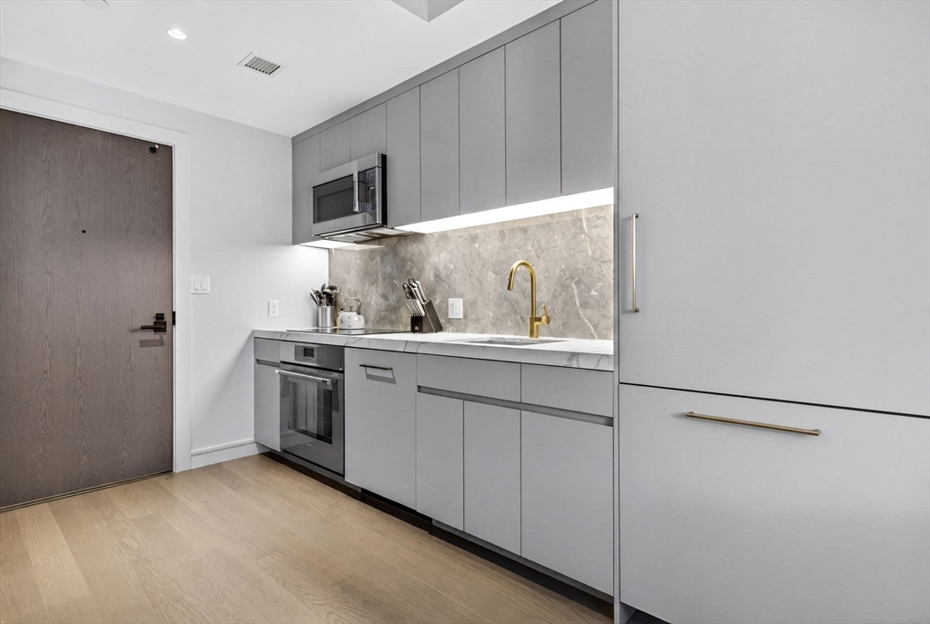 55 Lagrange Street, Unit 409 Boston, MA 02111 - Photo 7 of 29 a kitchen with stainless steel appliances a sink and a refrigerator