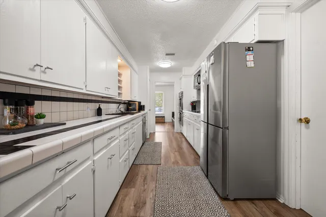 a kitchen with stainless steel appliances a sink dishwasher and cabinets with wooden floor