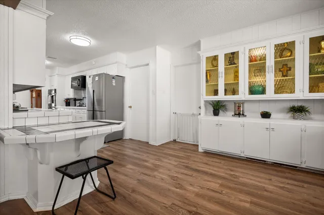 a view of kitchen with kitchen island a stove a sink and a large window