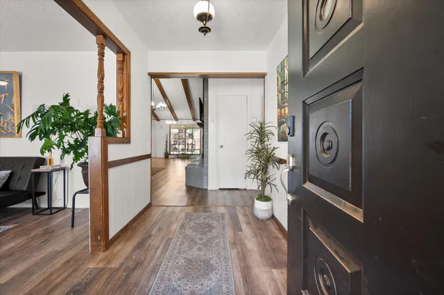 a view of a hallway with wooden floor and a potted plant