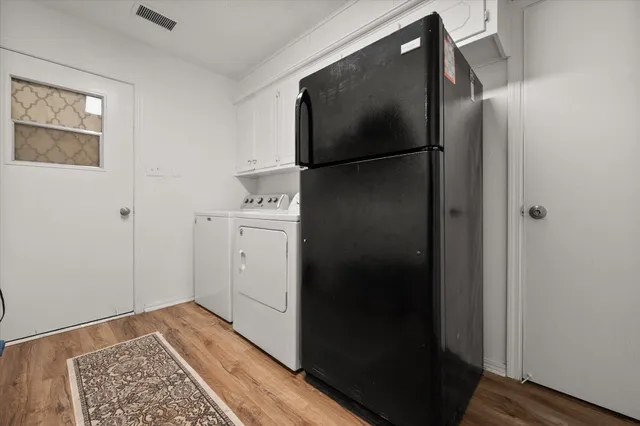 a bedroom with a bed and a view of closet with wooden floor