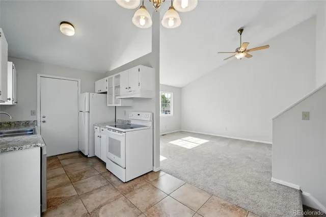 a kitchen with granite countertop a stove a sink and dishwasher