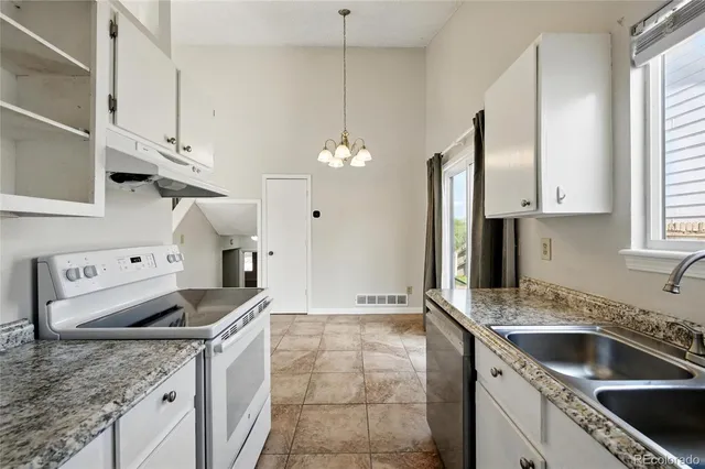 a kitchen with stainless steel appliances granite countertop a sink a stove and a refrigerator