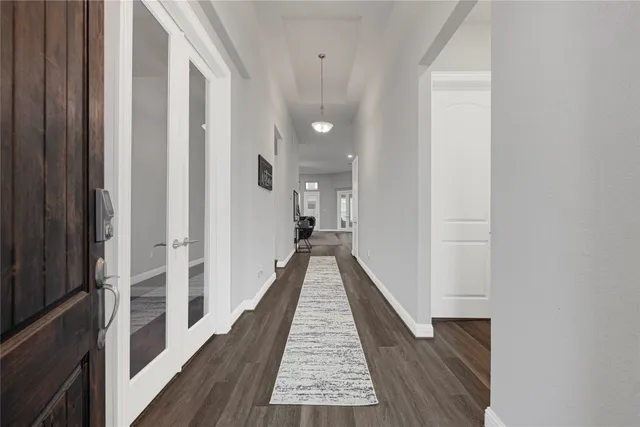a view of a hallway with wooden floor and staircase