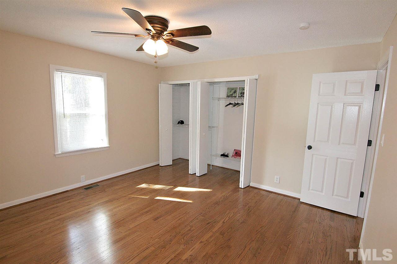 3404 Victor Place Raleigh, NC 27604 - Photo 12 of 22 a view of an empty room with wooden floor and a ceiling fan