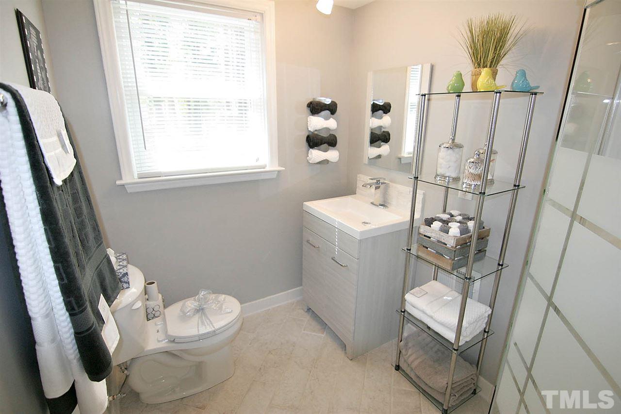 3404 Victor Place Raleigh, NC 27604 - Photo 16 of 22 a white toilet sitting next to a bathroom sink and a window