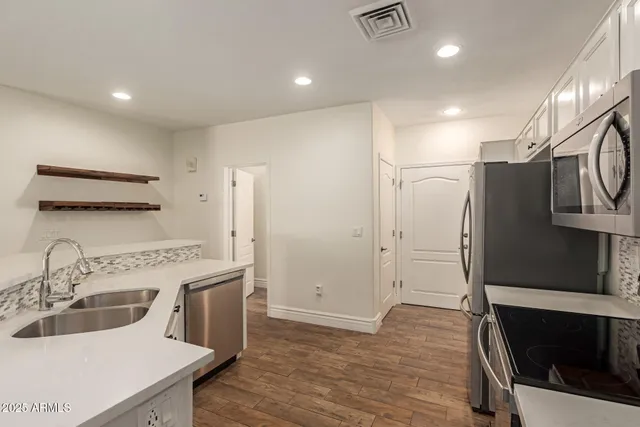 a kitchen with a sink a refrigerator and a stove top oven