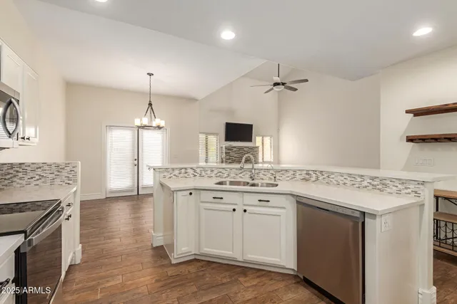 a hall with kitchen island a sink stainless steel appliances and cabinets