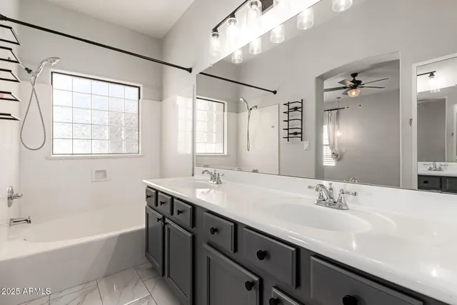 a bathroom with a granite countertop sink mirror bathtub and double