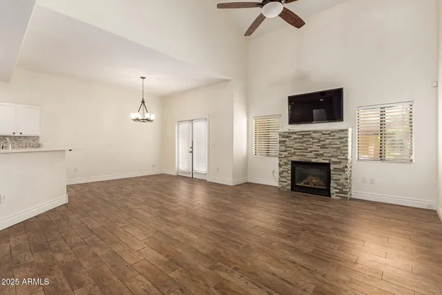 a view of empty room with fireplace and wooden floor