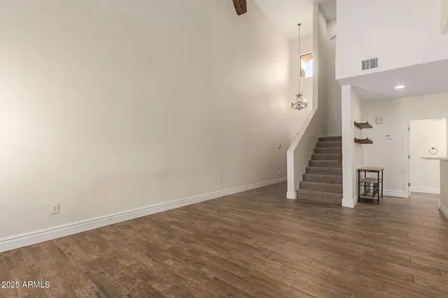 an empty room with wooden floor and stairs