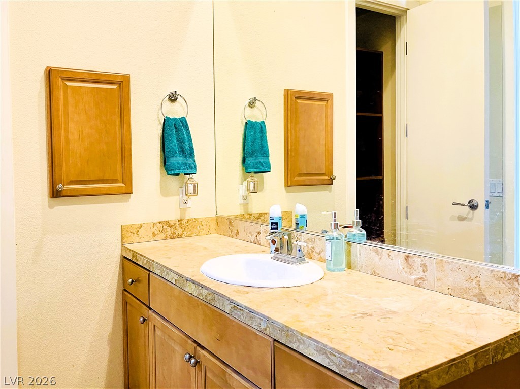 360 East Desert Inn Road, Unit 507 Las Vegas, NV 89109 - Photo 22 of 37 Natural stone countertops elevate this functional bathroom space.