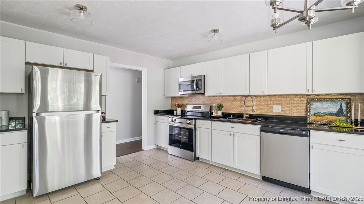 316 Patterson Street Raeford, NC 28376 - Photo 11 of 39 a kitchen with white cabinets and stainless steel appliances