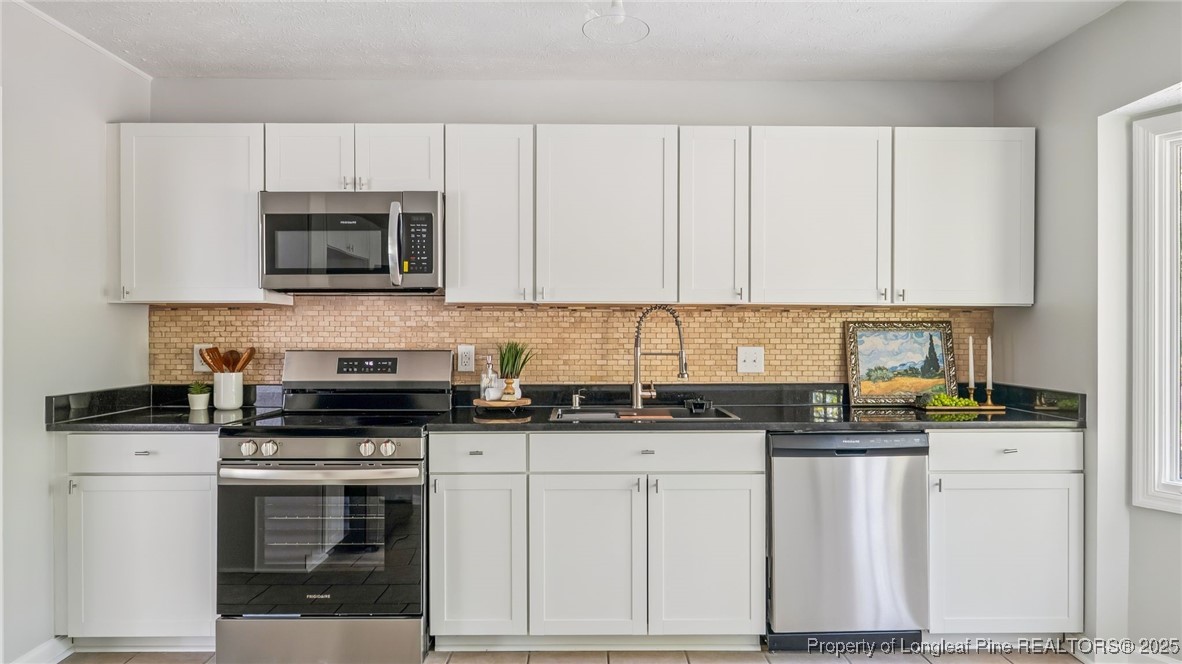 316 Patterson Street Raeford, NC 28376 - Photo 12 of 39 a kitchen with granite countertop white cabinets and stainless steel appliances