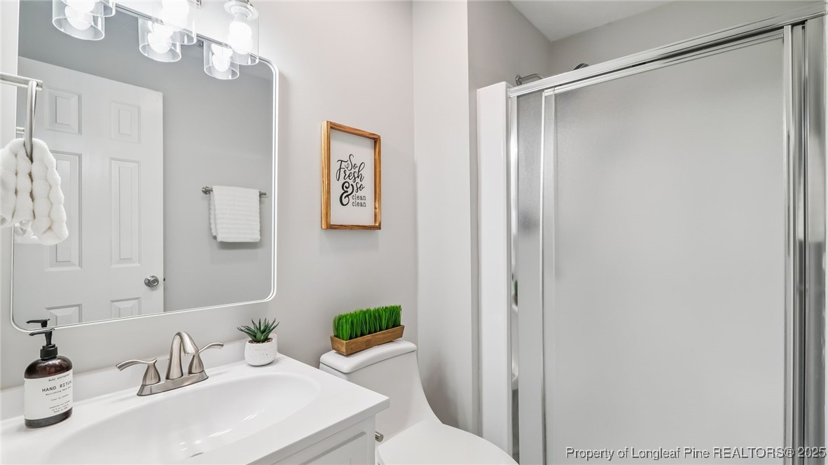 316 Patterson Street Raeford, NC 28376 - Photo 30 of 39 a bathroom with a sink vanity mirror and toilet