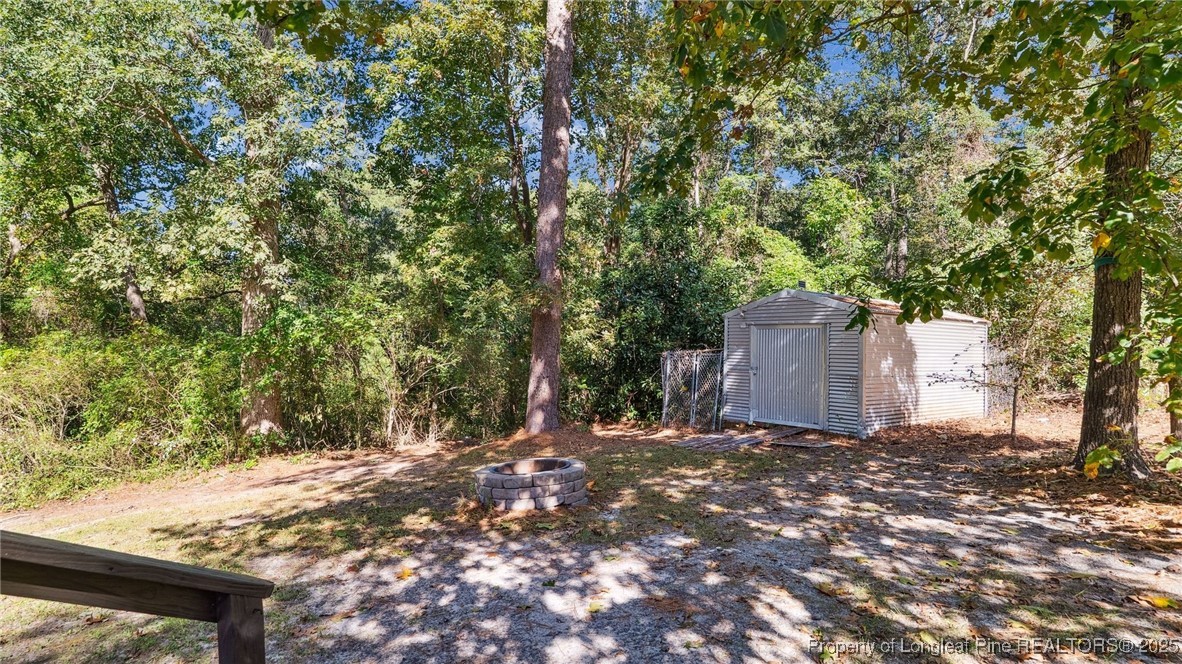 316 Patterson Street Raeford, NC 28376 - Photo 39 of 39 a backyard of a house with large trees and wooden fence