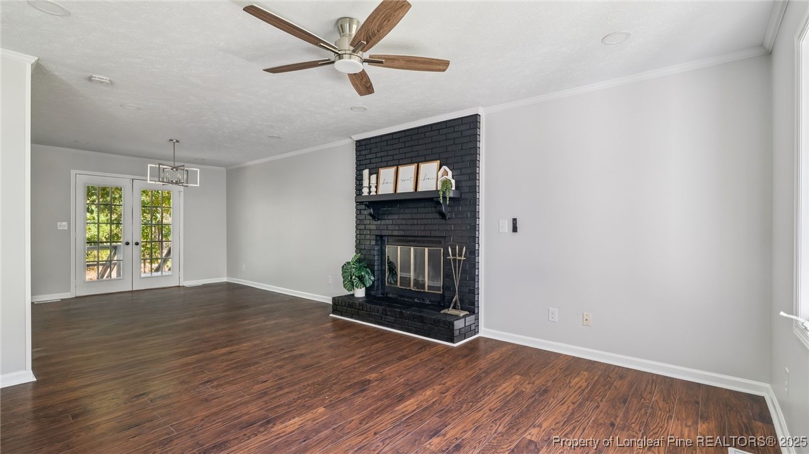 316 Patterson Street Raeford, NC 28376 - Photo 5 of 39 an empty room with wooden floor chandelier fan and windows