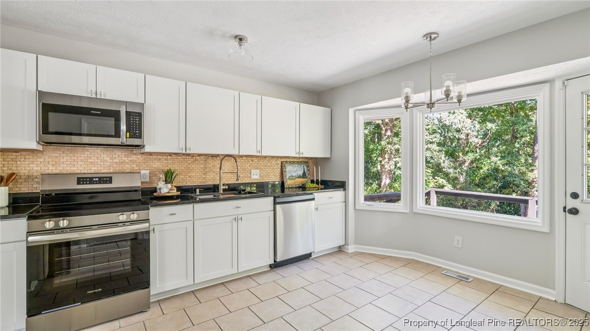 316 Patterson Street Raeford, NC 28376 - Photo 10 of 39 a kitchen with granite countertop cabinets stainless steel appliances and a window
