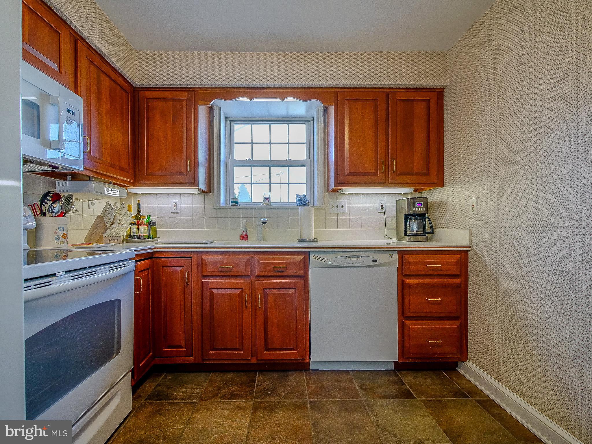 204 East Thomson Avenue Springfield, PA 19064 - Photo 20 of 58 a kitchen with stainless steel appliances granite countertop a stove a sink dishwasher and a microwave oven with cabinets