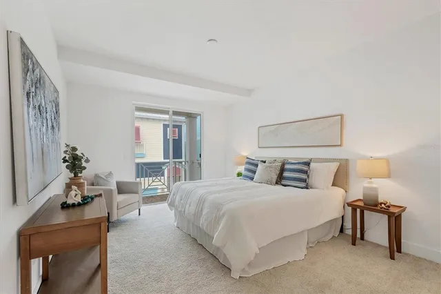 a bedroom with a bed and potted plant on table