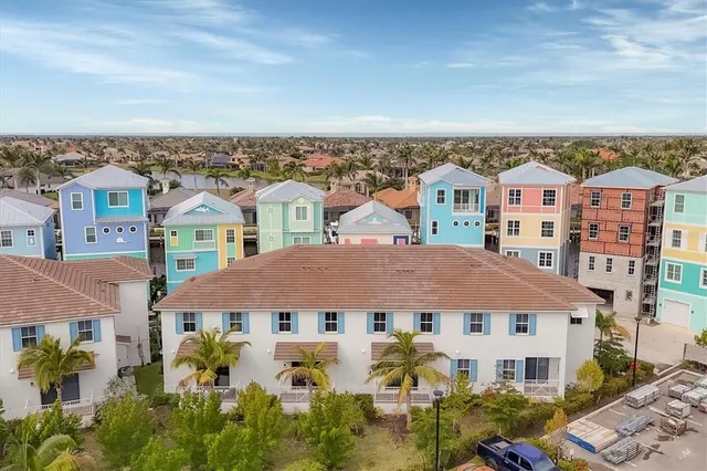 an aerial view of a city with lots of residential buildings ocean and mountain view in back