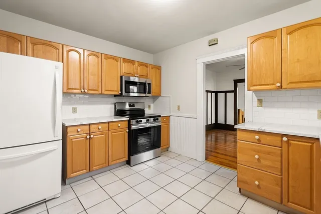 a kitchen with stainless steel appliances granite countertop a refrigerator sink and stove