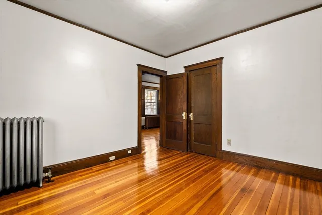a view of an empty room with wooden floor