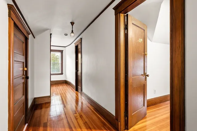 a view of a hallway with wooden floor and staircase