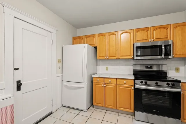 a white refrigerator freezer and a stove in a kitchen