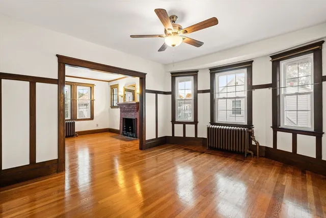a view of an empty room with window and a kitchen view