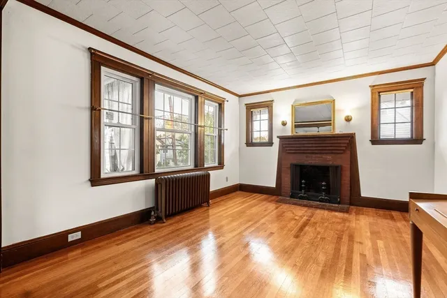 a view of an empty room with window and fire place