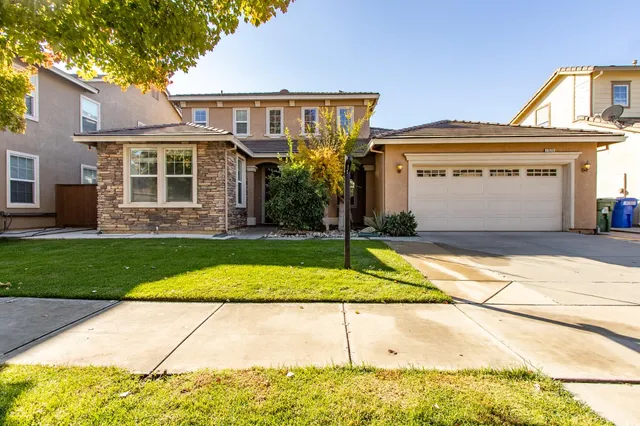 a front view of a house with a yard and garage
