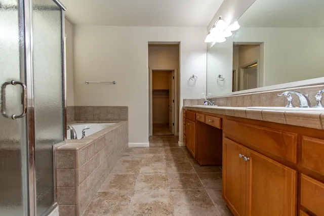 a spacious bathroom with a tub sink and mirror