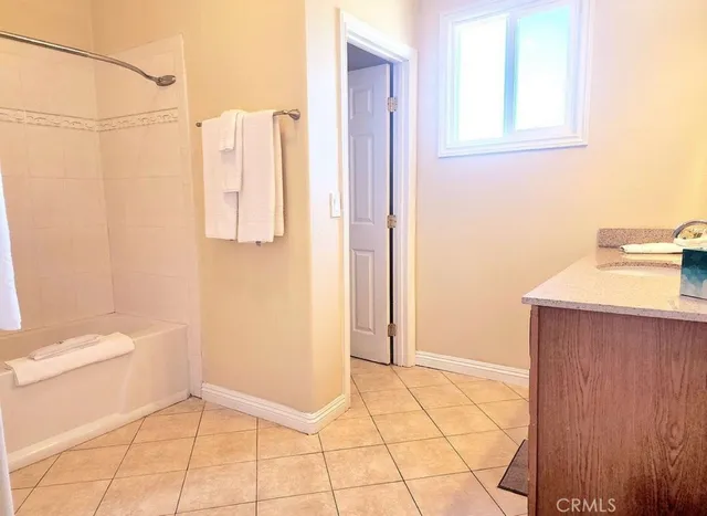 a large kitchen with stainless steel appliances wooden floor and a refrigerator