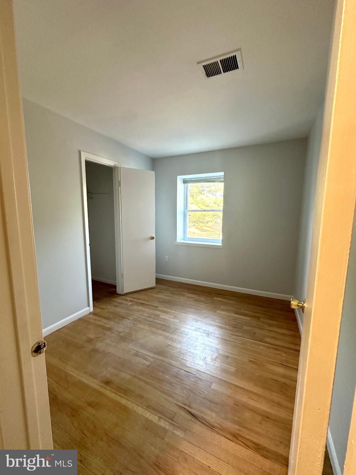 413 Silver Court Hamilton, NJ 08690 - Photo 6 of 7 a view of an empty room with wooden floor and a window