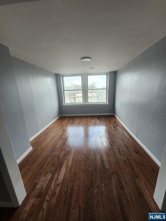 316 South Orange Avenue, Unit 2N Newark, NJ 07103 - Photo 3 of 10 an empty room with wooden floor and windows