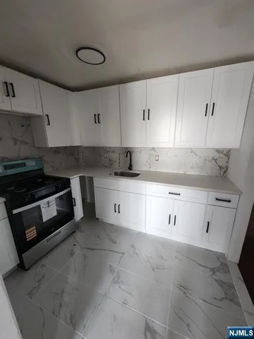 a kitchen with granite countertop white cabinets and white appliances