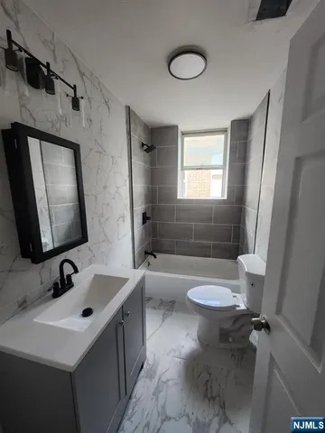 a bathroom with a toilet a sink a mirror and a bathtub